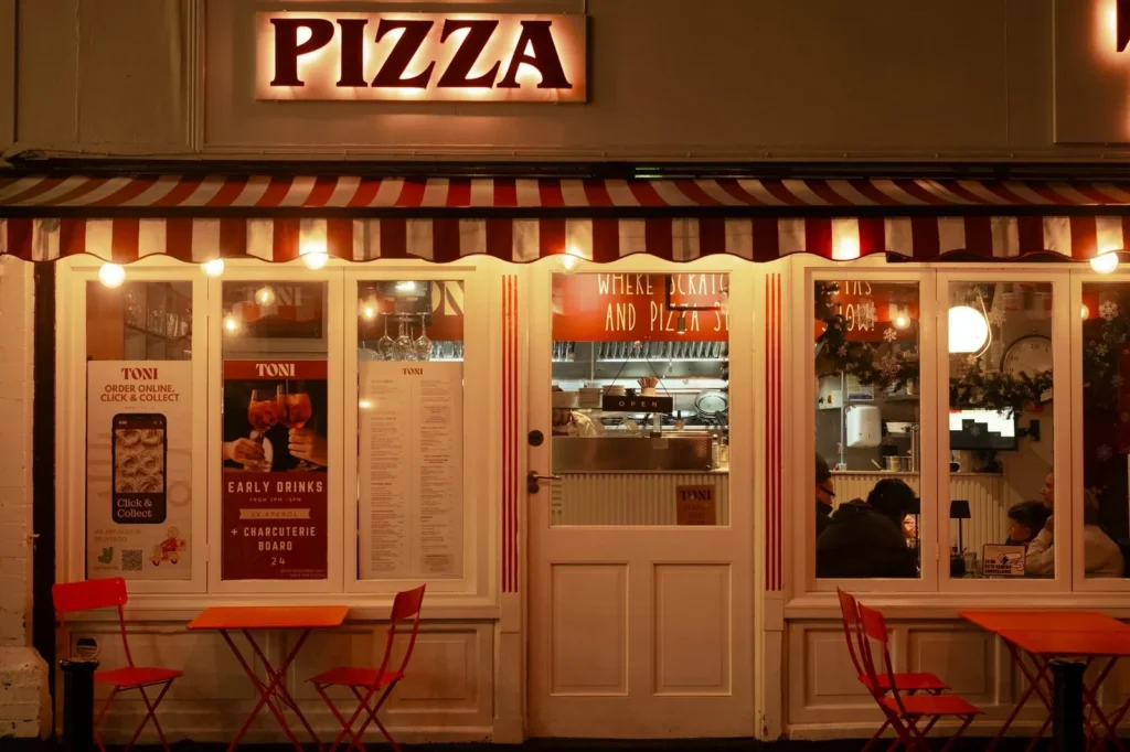 Restaurant storefront with a striped awning at night